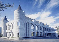 壁から張り出している円柱形の小塔が西洋風のお城のような、2階建ての白いレンガ調の外壁をした美里町役場中央庁舎の外観写真
